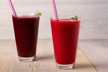 Frozen summer berries smoothie: blueberries, strawberries, raspberries, cranberries, currants and blackberries on wooden background, horizontal