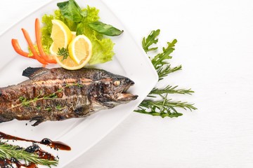 Fish Trout baked with vegetables and spices. On a wooden background. Top view. Free space for text.