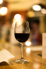 Wine glass filled with red wine on table in pub