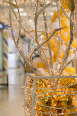 abstract artificial tree of metal tubes, garlands and yellow balls