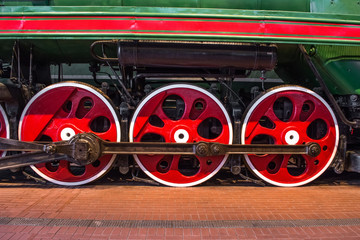 Wheels of an old steam locomotive close up.