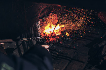Blacksmith at work with glowing irons. Hot iron forge, a blacksmith at work with red-hot iron.