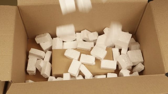 Person packs up the boxes with the gifts into the big  cardboard carton 