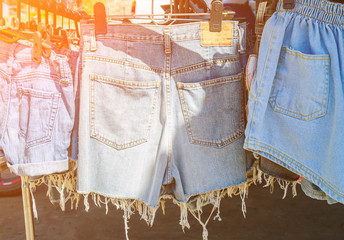 Morning sunlight shines blue jeans shorts washing line