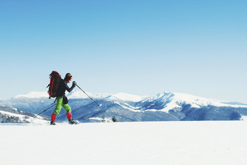 Winter hike in the mountains with a backpack and tent.