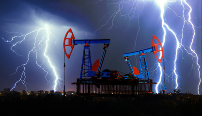 Pumpjack in an oil field during a thunderstorm and lightning. © yevgeniy11