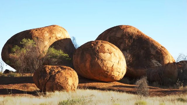 a group of round devil's marbles in australia's northern territory in the morning