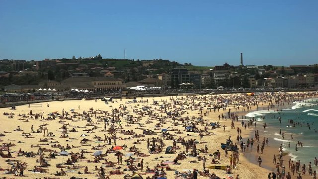 panning right shot of summer crowds at bondi beach, australia's most famous beach