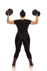 Chubby woman posing with weights in fitness clothing on white background