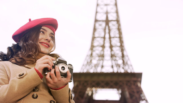 Creative girl holding camera in hands, enjoying photography hobby in Paris