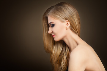 Healthy Blonde Woman with Long Hair on Dark Background with Copy space