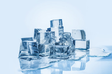 Obraz premium Melting ice cubes on blue background