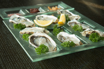 Oysters on glass plate with spicy sauce