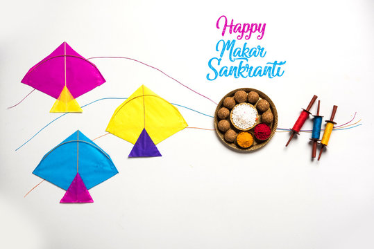 happy Makar Sankranti greeting card - Tilgul or Til ladoo in a bowl or plate with haldi kumkum and flowers with Fikri /Reel/Chakri /Spool with colourful thread or manjha and kite 