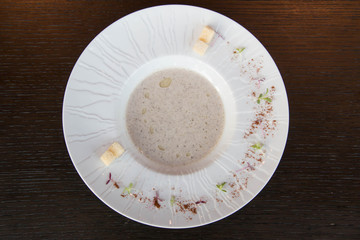  plate of mushroom soup on wood plate