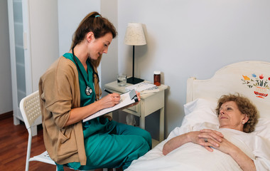 Female doctor filling out a questionnaire to a senior patient