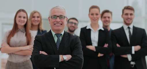 Mature businessman and cheerful business team on office backgrou