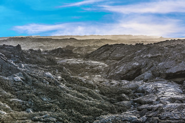 Fototapeta na wymiar coast with Stones of volcanic flow and ocean