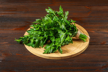 A bunch of green parsley on a wooden table.