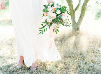 Low section of woman holding bridal bouquet