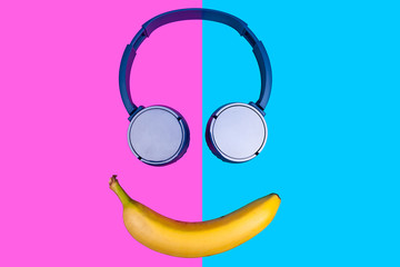 Pop art flat concept of banana and headphones on vivid colored background forming a smile face. Flat style and colors