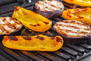 Vegetables: aubergines and yellow pepper on an electric grill. Close-up. Healthy Eating
