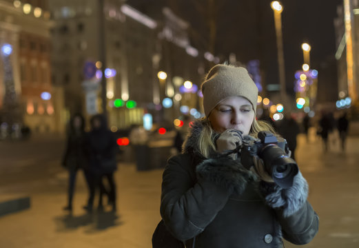 Woman photographer makes photos in the night city