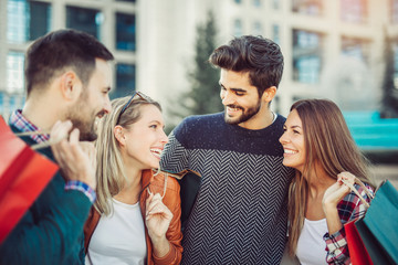 Group Of Friends Walking Along Street With Shopping Bags