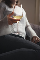 Adult woman relaxes and drinks a glass of wine