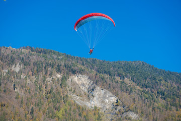 Paragliders flying with a paramotors with beautiful mountain view against blue sky