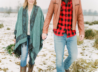 cowboy style couple walking in snow