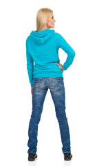Fototapeta premium Woman In Turquoise Hoodie Is Standing And Looking Away. Rear View.