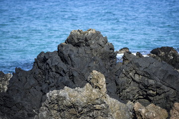 Volcanic rocks protruding from the assessment at the coast of the island of Lanzarote