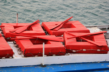 Red square liferafts with paddles on roof of old pleasure boat