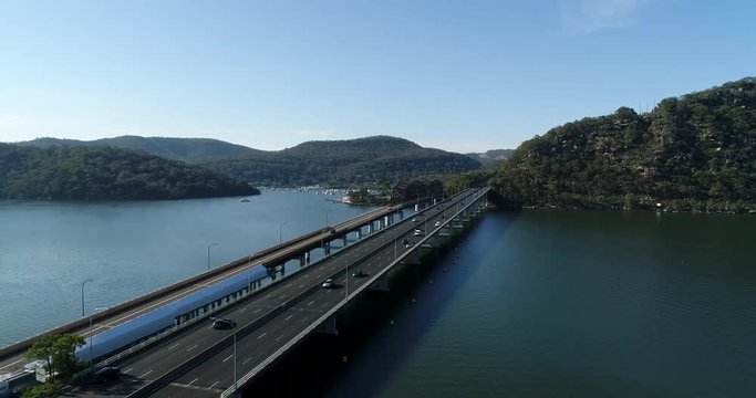 Hawkesbury river on Australian central coast off Greater Sydney with M1 highway bridge aerial panning over water.

