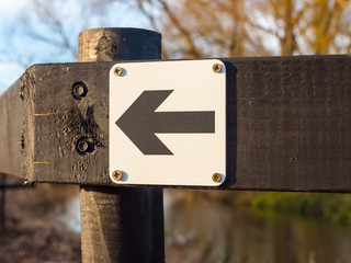 black and white direction way sign left black wooden post outside close up