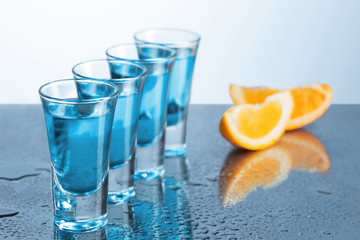 Vodka glass with ice on blue background