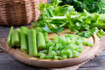 Sliced frozen celery on a cutting wooden board