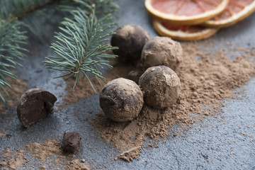 chocolate truffles with cocoa powder on the  dark background  and christmas decoration 