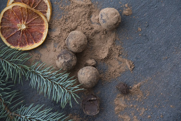 chocolate truffles with cocoa powder on the  dark background  and christmas decoration 