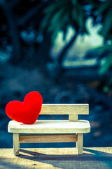 red heart on the wooden bench with dramatic tone