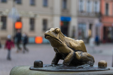Bronze sculpture of one frog, a part of the Rafter’s Monument in the Old Town Marketplace, Torun, Poland