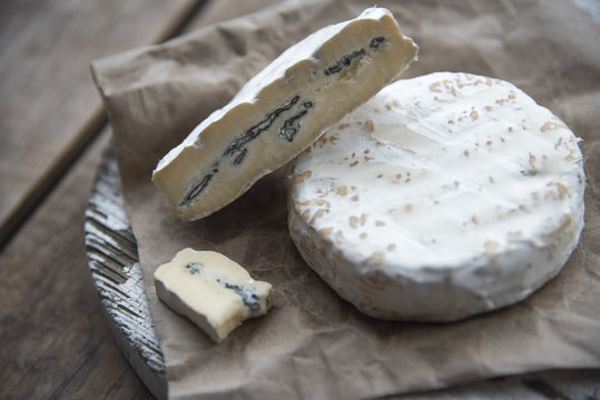 camembert cheese with blue mold on the wooden background 