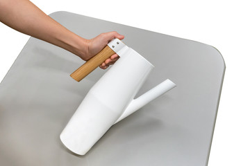 Hand holding modern jug on grey table