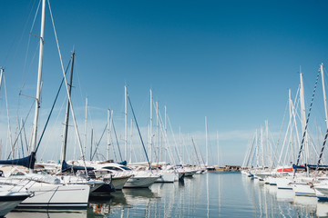 Yacht parking in harbor, harbor yacht club in Marina di Scarlino, Italy. Beautiful Yachts in blue sky background