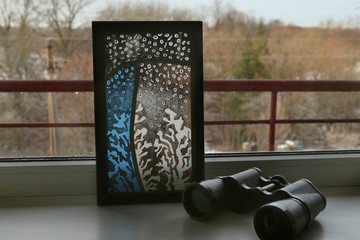 Stained glass with frosty drawing on windowsill. Handmade stained glass graphic pictures. - obrazy, fototapety, plakaty