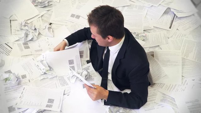 the man in the office drowning in paper