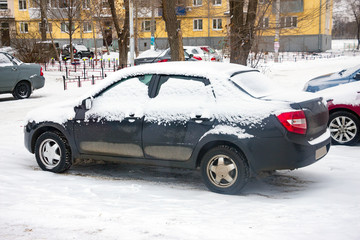The cars in the Parking lot in the winter. Car covered with snow