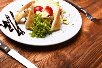 Fototapeta na wymiar Caesar salad with white dressing and parmesan on top
