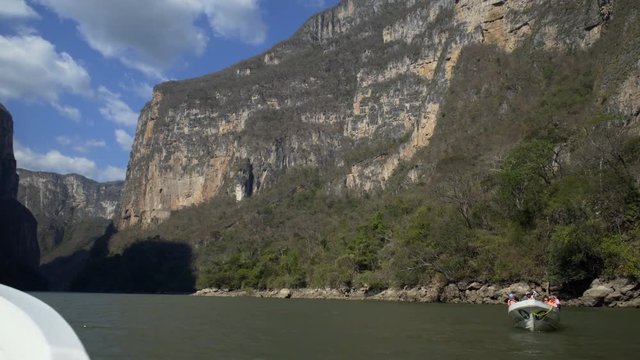 driving on boat,view out of boat, landscape with high stone wall, river and blue sky,  tour in the Sumidero Canyon - Chiapas, Mexico
